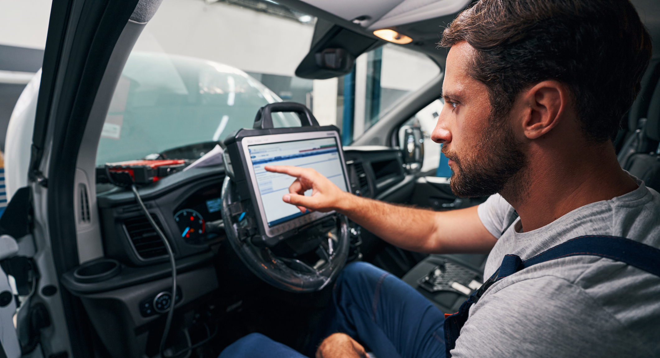 Auto mechanic providing car diagnostics in cabin